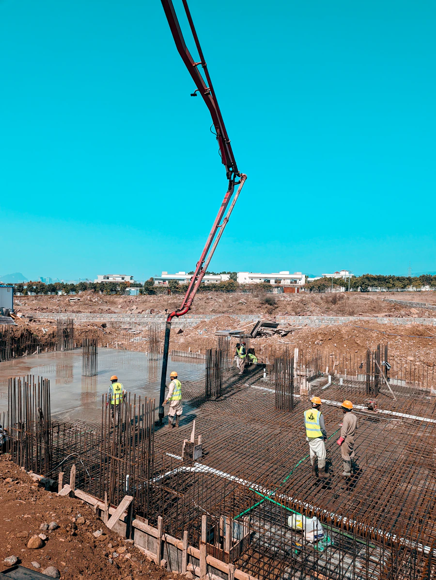 Construction crew pouring concrete on a plot of land